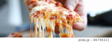 Male arm taking slice of cheesy tasty fresh pizza 66746321