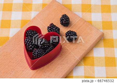 Heart-shaped form filled with natural fresh ripe blackberries. 66746532