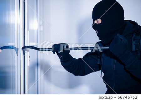 Robber in black balaclava cracking door with the crowbar Robber in black balaclava cracking door with the crowbar 66746752