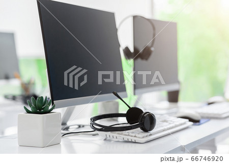 Call center and customer service. Computer monitor with blank space for your design and VOIP headset on desk in office Call center and customer service. Computer monitor with blank space for your design and VOIP headset on desk in office 66746920
