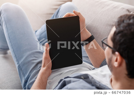 Reading books or blog and job search online. Man looks at tablet Reading books or blog and job search online. Man looks at tablet 66747036