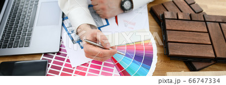 Male designer hand hold silver pen against color palette trend 66747334