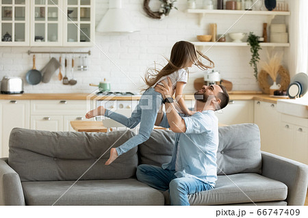 Adorable preschool son flying with hands outstretched in caring father. 66747409