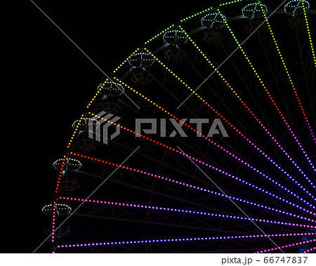 ferris wheel with colored lights in an amusement park at night on a black background 66747837