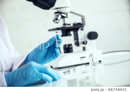 Hands holds a syringe. Hands in medical gloves Hands holds a syringe. Hands in medical gloves 66748042