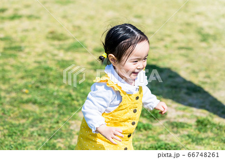 子供と家族 公園で遊ぶ可愛い女の子の写真素材