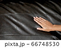 The woman's hand touching the surface of the sofa. 66748530