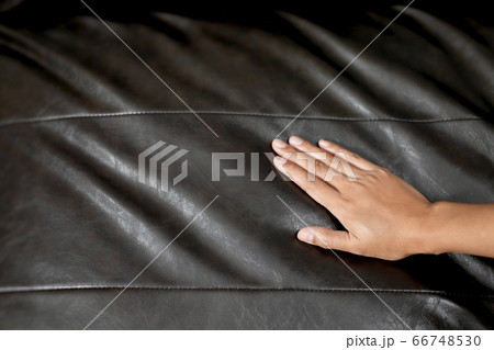 The woman's hand touching the surface of the sofa. The woman's hand touching the surface of the sofa. 66748530