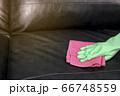 Woman wipe sofa with germicidal spray and wipe with towel. 66748559