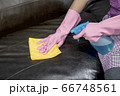Woman wipe sofa with germicidal spray and wipe with towel. 66748561