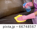 Woman wipe sofa with germicidal spray and wipe with towel. 66748567