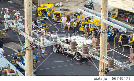 Power lines in the city. Transformers and phone lines against road in Filipino city. 66749472