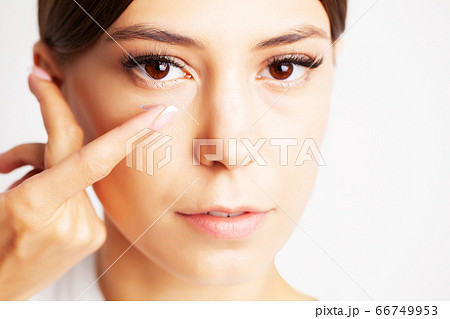 Pretty young woman puts on contact lenses for eyesight Pretty young woman puts on contact lenses for eyesight 66749953