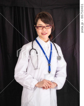 上半身で真顔の黒背景のミドルエイジの女性医師　 66750401