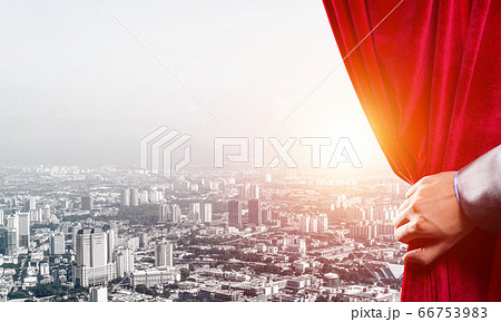 Modern business cityscape behind curtain opened by businessman hand 66753983