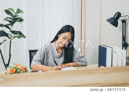Beautiful young asian woman writing diary or story from home Beautiful young asian woman writing diary or story from home 66757372