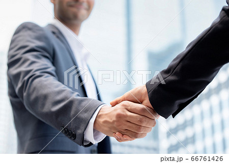 Businessman making handshake with partner outdoors 66761426