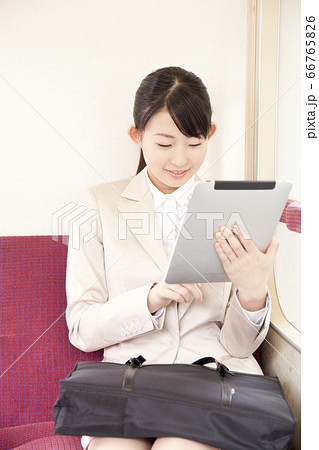 電車でタブレットPCを見るOL 電車でタブレットPCを見るOL 66765826