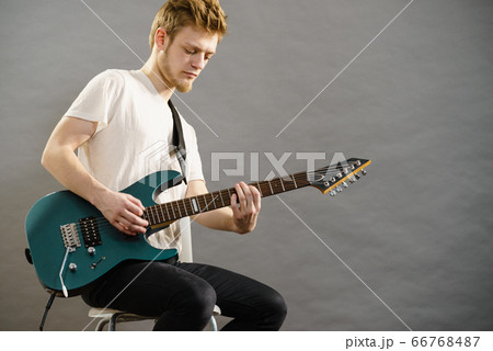 Young man playing electric guitar Young man playing electric guitar 66768487