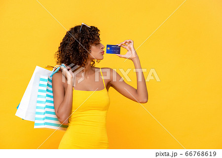 Fashionable curly hair woman with credit card and shopping bags 66768619