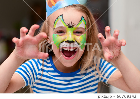 Child in makeup growls with claws hands 66769342