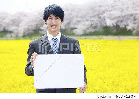 メッセージボードを持つ新入社員 66771207