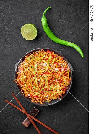 Chinese Bhel in bowl on black table top. Indo-Chinese cuisine street food dish with schezwan sauce Chinese Bhel in bowl on black table top. Indo-Chinese cuisine street food dish with schezwan sauce 66773879