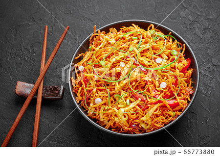 Chinese Bhel in bowl on black table top. Indo-Chinese cuisine street food dish with schezwan sauce Chinese Bhel in bowl on black table top. Indo-Chinese cuisine street food dish with schezwan sauce 66773880