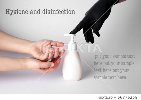 Someone gives a disinfectant gel to the hands of another person Someone gives a disinfectant gel to the hands of another person 66776258