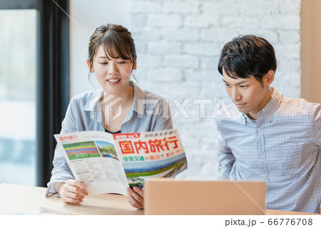 旅行のパンフレットを見ながら計画を立てる男女 旅行のパンフレットを見ながら計画を立てる男女 66776708