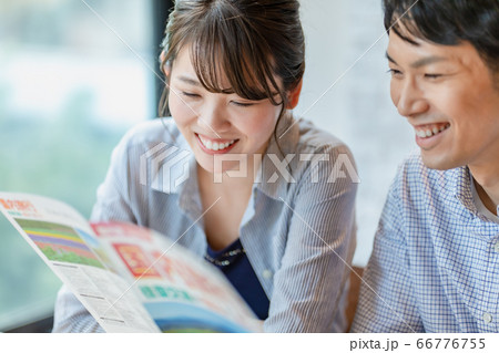 旅行のパンフレットを見ながら計画を立てる男女 旅行のパンフレットを見ながら計画を立てる男女 66776755