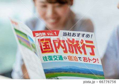 旅行のパンフレットを見ながら計画を立てる男女 66776756