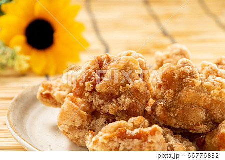 若鶏もも肉の唐揚げ(竜田揚げ)。背景すだれと向日葵(ひまわり)で夏イメージ。 若鶏もも肉の唐揚げ(竜田揚げ)。背景すだれと向日葵(ひまわり)で夏イメージ。 66776832