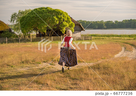 Latvian woman in traditional clothing in field. Latvian woman in traditional clothing in field. 66777236