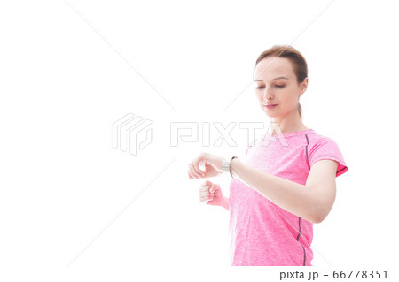 スマートウォッチを確認するスポーツウェアを着た若い女性 スマートウォッチを確認するスポーツウェアを着た若い女性 66778351