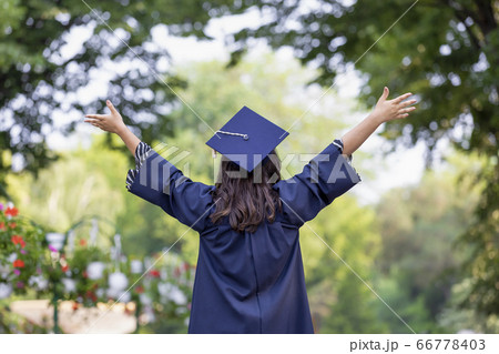 Happy young woman graduating with hands up 66778403