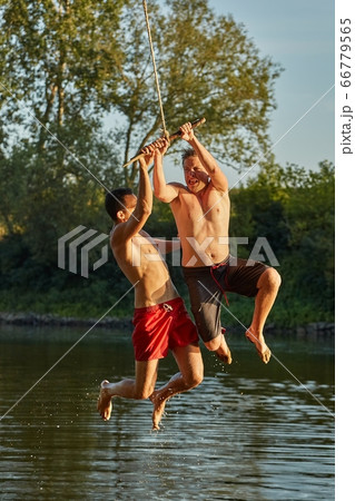Guys jumping in a river 66779565