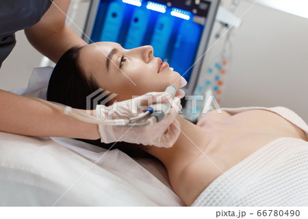 Professional female cosmetologist doing hydrafacial procedure in Cosmetology clinic. 66780490