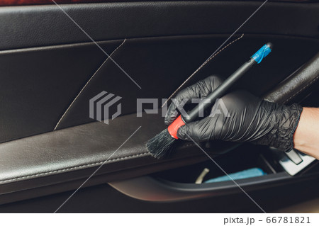 A man cleaning car with cloth and brush. Car detailing. Selective focus. Car detailing. Cleaning with brush. Worker cleaning. Brush and cleaning solution to clean. A man cleaning car with cloth and brush. Car detailing. Selective focus. Car detailing. Cleaning with brush. Worker cleaning. Brush and cleaning solution to clean. 66781821