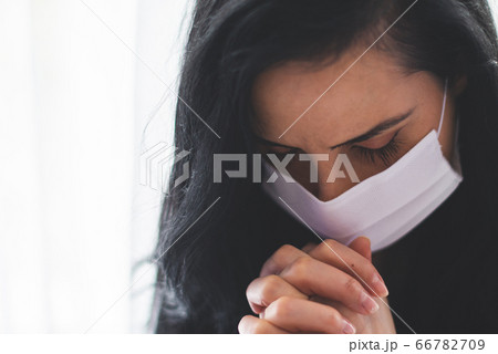 Portrait of woman with surgical mask praying 66782709