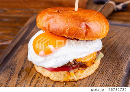 Burger with marble beef cutlet, cheese, tomatoes, lettuce leaves and egg 66782722