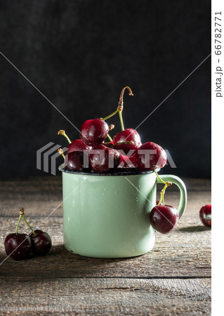 Ripe cherries in a green pot Ripe cherries in a green pot 66782771