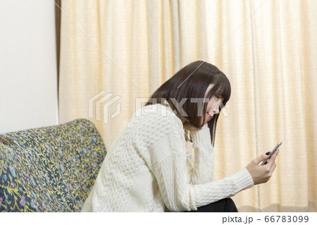 スマホを扱う女性 66783099