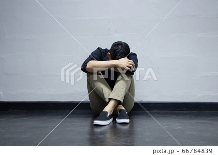 The Depression Businessman Sitting Near the Wall on the Floor 66784839