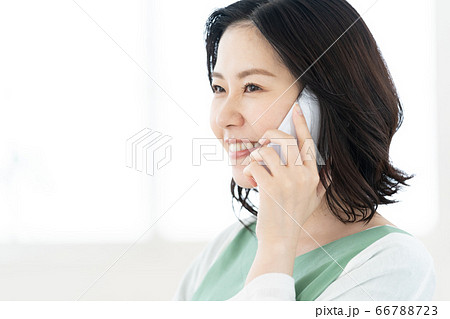スマホで通話するミドル女性【リビング】 スマホで通話するミドル女性【リビング】 66788723