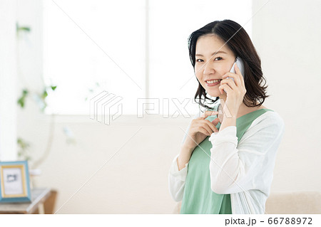 スマホで通話するミドル女性【リビング】 スマホで通話するミドル女性【リビング】 66788972