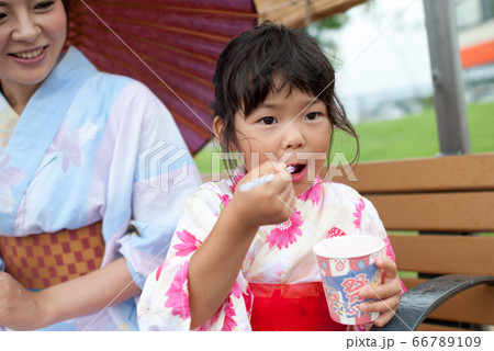 屋外でかき氷を食べる浴衣を着た、お母さんと浴衣を着たの女の子 66789109