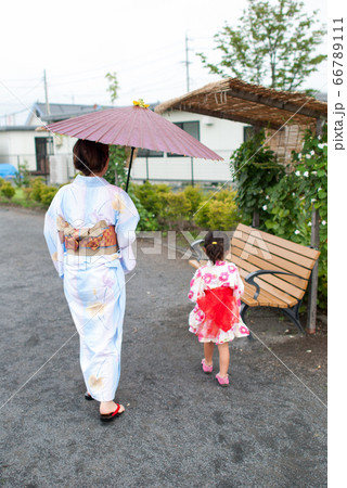 屋外でかき氷を食べる浴衣を着た、お母さんと浴衣を着たの女の子 66789111