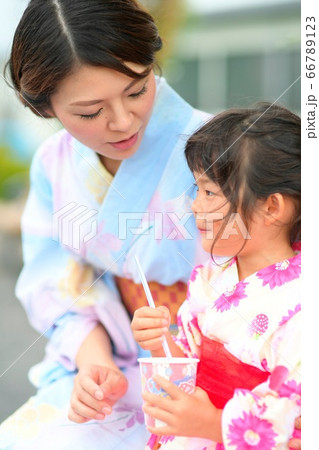 屋外でかき氷を食べる浴衣を着た、お母さんと浴衣を着たの女の子 66789123