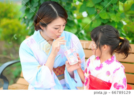 屋外でかき氷を食べる浴衣を着た、お母さんと浴衣を着たの女の子 66789129